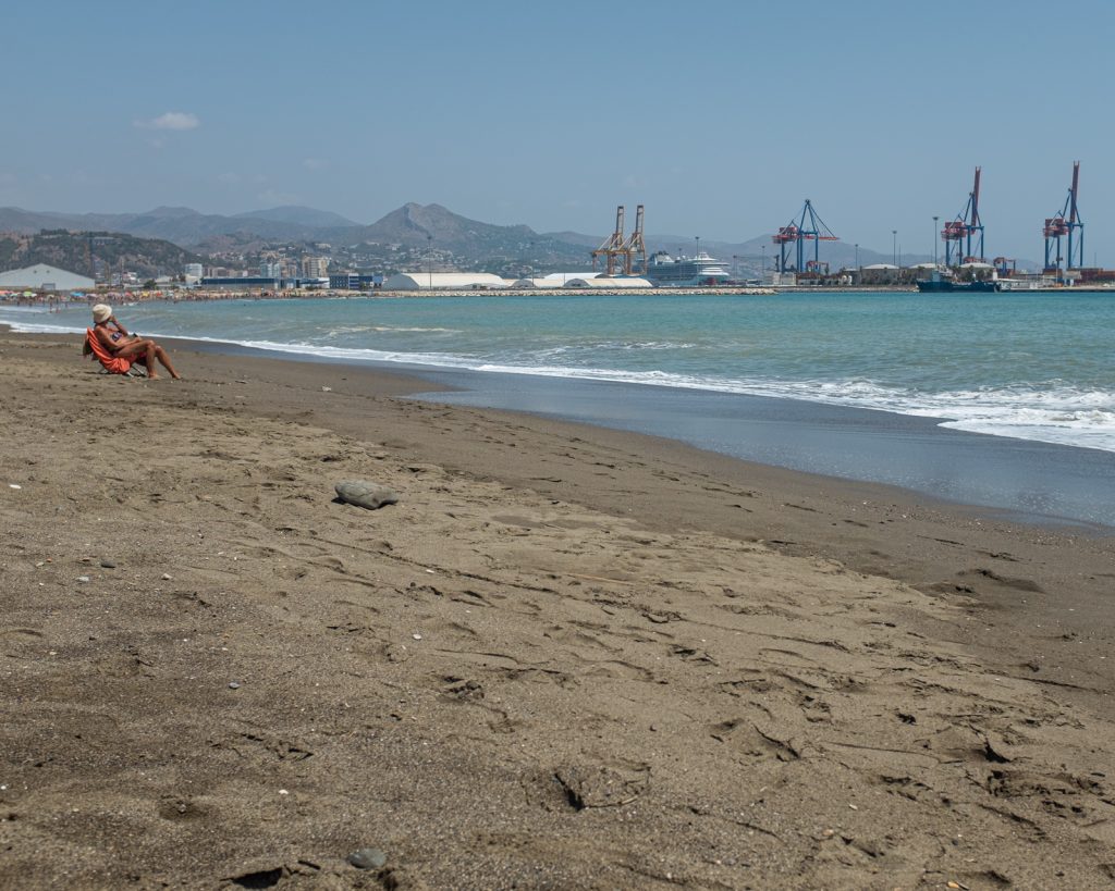 The port with all its noise and big cranes always lurks in the background of otherwise idyllic photos from the Malaga beach.