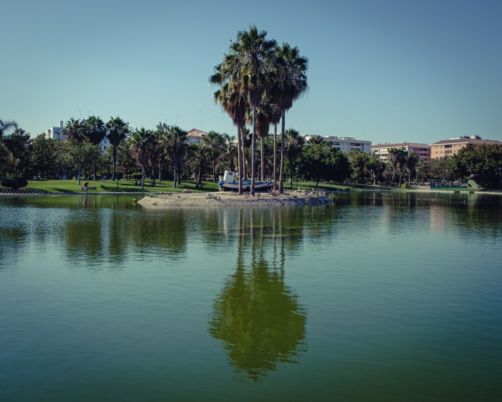 In the middle of the park, there were a boat placed on an island in a small lake.